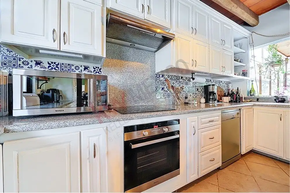 Bright, modern kitchen with white cabinetry and stainless steel appliances in Rancho Los Labradores.