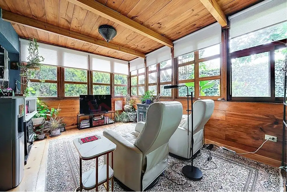 Style living room with wooden walls and large windows in Rancho Los Labradores.