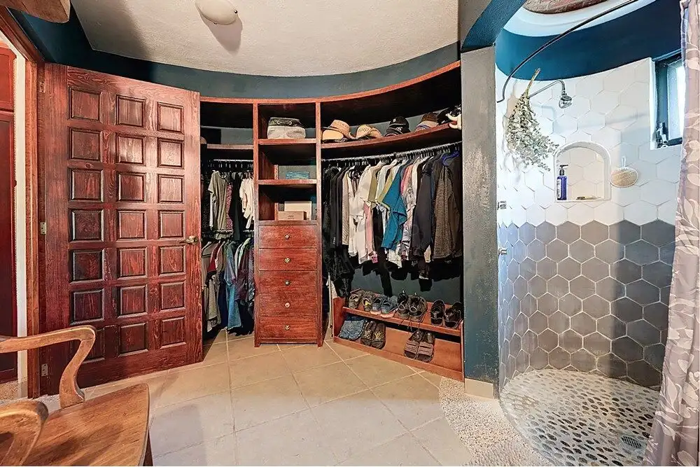 In closet with wooden shelves and hanging space in a colonial-style home.