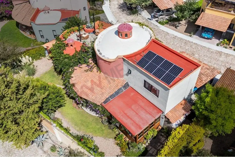 Aerial view of a colonial-style home with solar panels in Rancho Los Labradores, San Miguel de Allen.