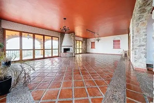 Interior of a Spanish Colonial estate with terracotta tiled floors and a cozy fireplace.