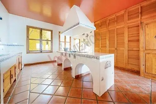 Traditional Spanish-style kitchen with terracotta tiles and wooden cabinets.