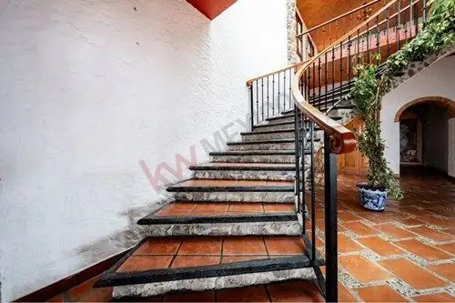 Elegant Spanish Colonial staircase with terracotta tiles and wrought iron railing in a luxurious est.