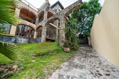 Elegant stone archway and lush greenery at a Spanish colonial estate in San Miguel de Allende.