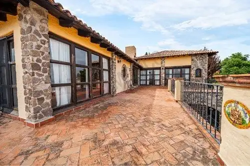 Spacious terrace of a Spanish colonial estate with stone walls and panoramic views in San Miguel de.
