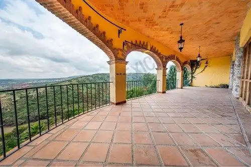 Balcony with arches and wrought iron railing overlooking lush landscape and scenic vistas in San Mig.