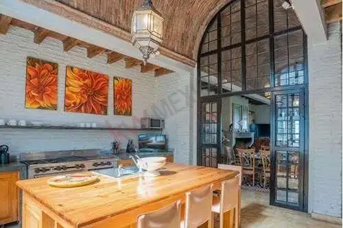 Spanish Colonial kitchen with arched glass doors, bright decor, and wooden accents in San Miguel de.