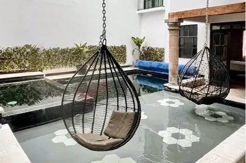 Modern outdoor pool with hanging lounge chairs in San Miguel de Allende.