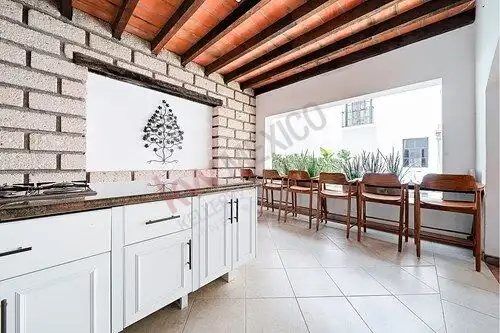 Bright kitchen with bar seating and rustic ceiling in San Miguel de Allende property.