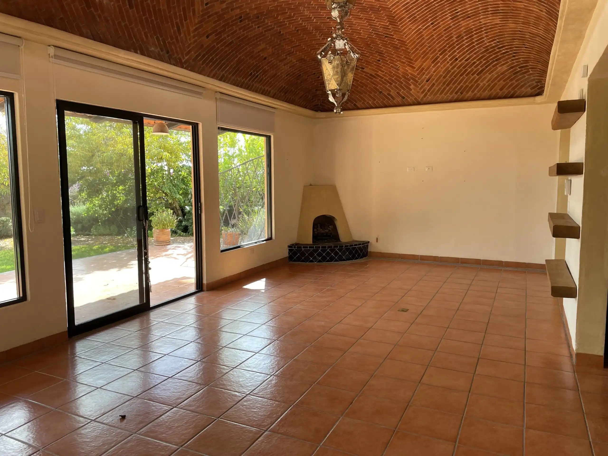 Spacious living room with large windows and terracotta tile flooring in a single-story home in Ranch.