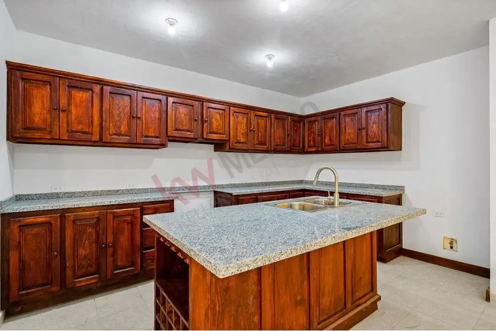 Spacious kitchen with wooden cabinets and granite countertops in a modern San Miguel de Allende home.