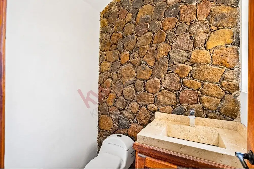 Bathroom with stone accent wall and modern fixtures in San Miguel de Allende.
