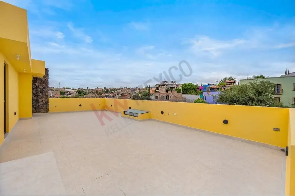 Terrace view of a modern home in Colonia San Rafael, San Miguel de Allende, with vibrant yellow wall.