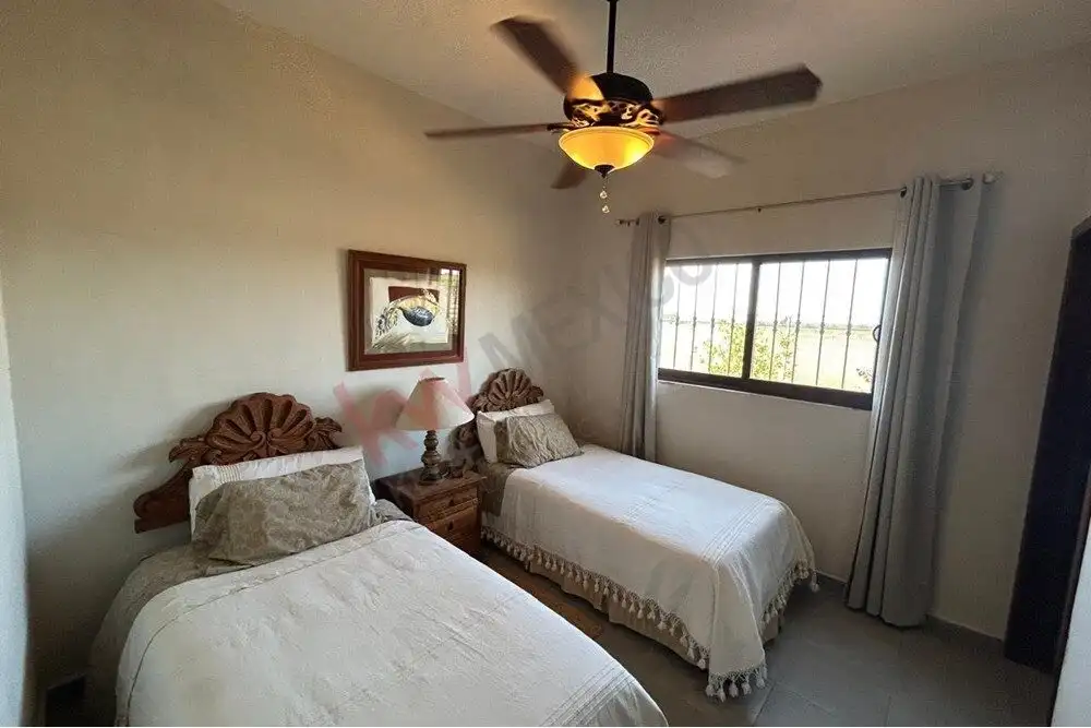 Luxury Country Estate for Sale in San Miguel de Allende – 30,000,000 MXN Elegant bedroom with twin beds, ceiling fan, and large window with curtains in a country estate.
