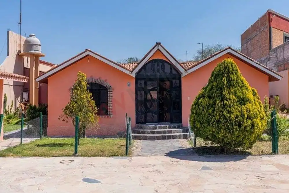 Cozy countryside retreat featuring a pink exterior, lush greenery, and a welcoming entrance, just mi.