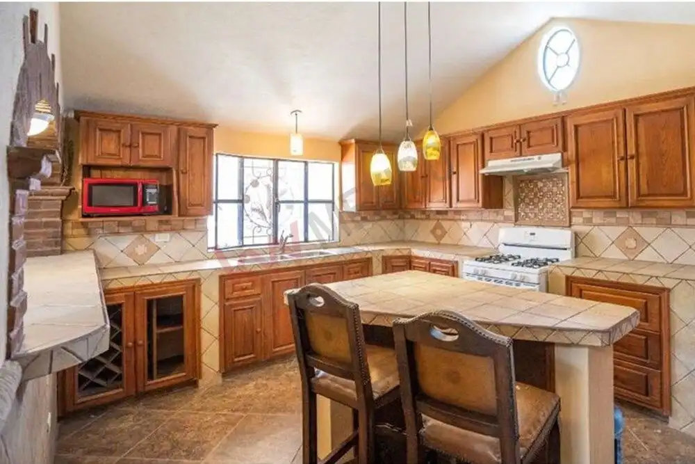 Spacious kitchen featuring warm wooden cabinetry, a central island, and contemporary appliances in a.