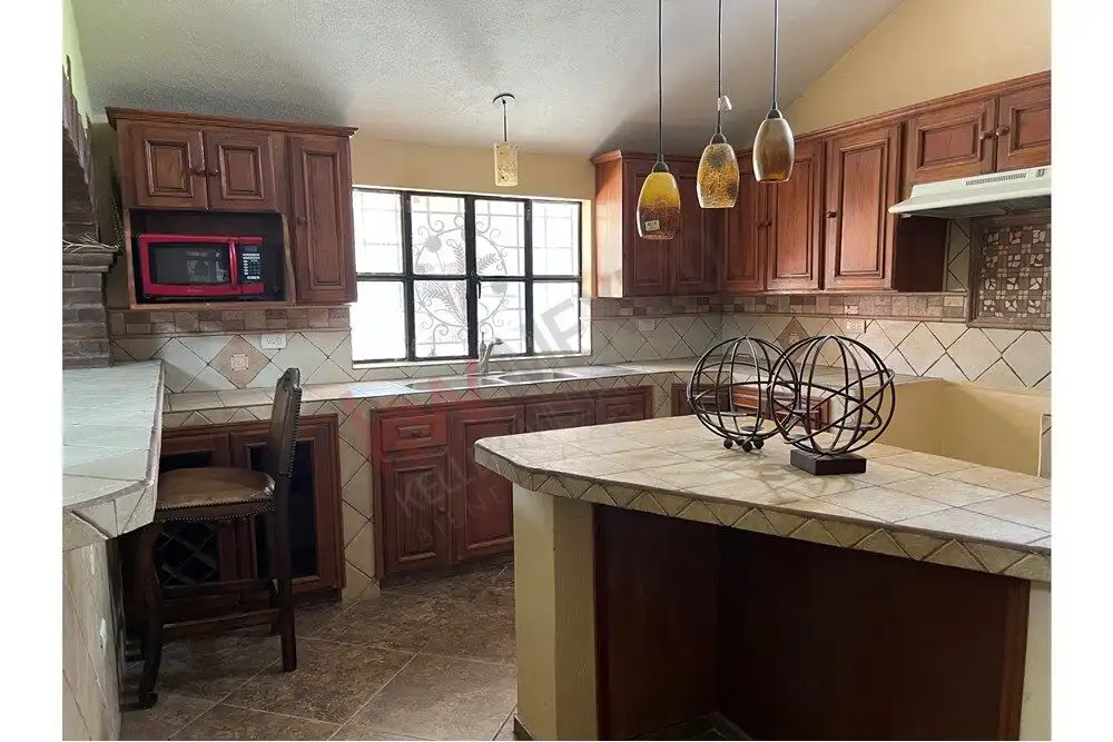 Bright kitchen featuring wooden cabinetry, a large window, and contemporary appliances for comfortab.