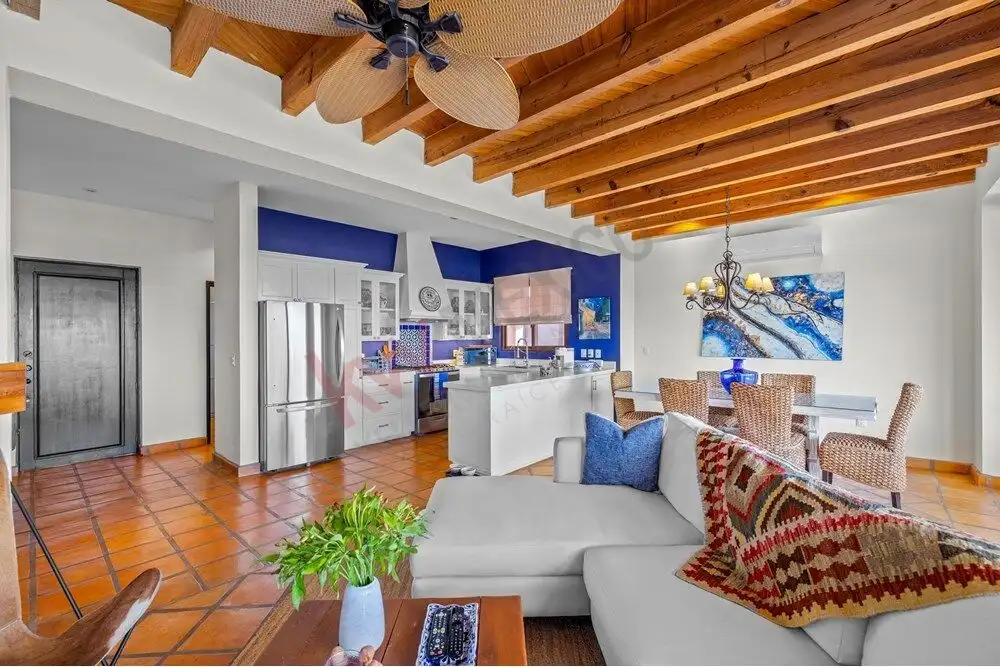 Bright living room with modern kitchen and wooden ceiling beams.