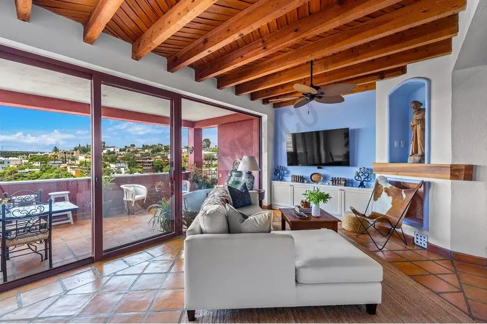 Bright living room with large glass doors opening to a spacious balcony. Modern decor and cozy ambia.