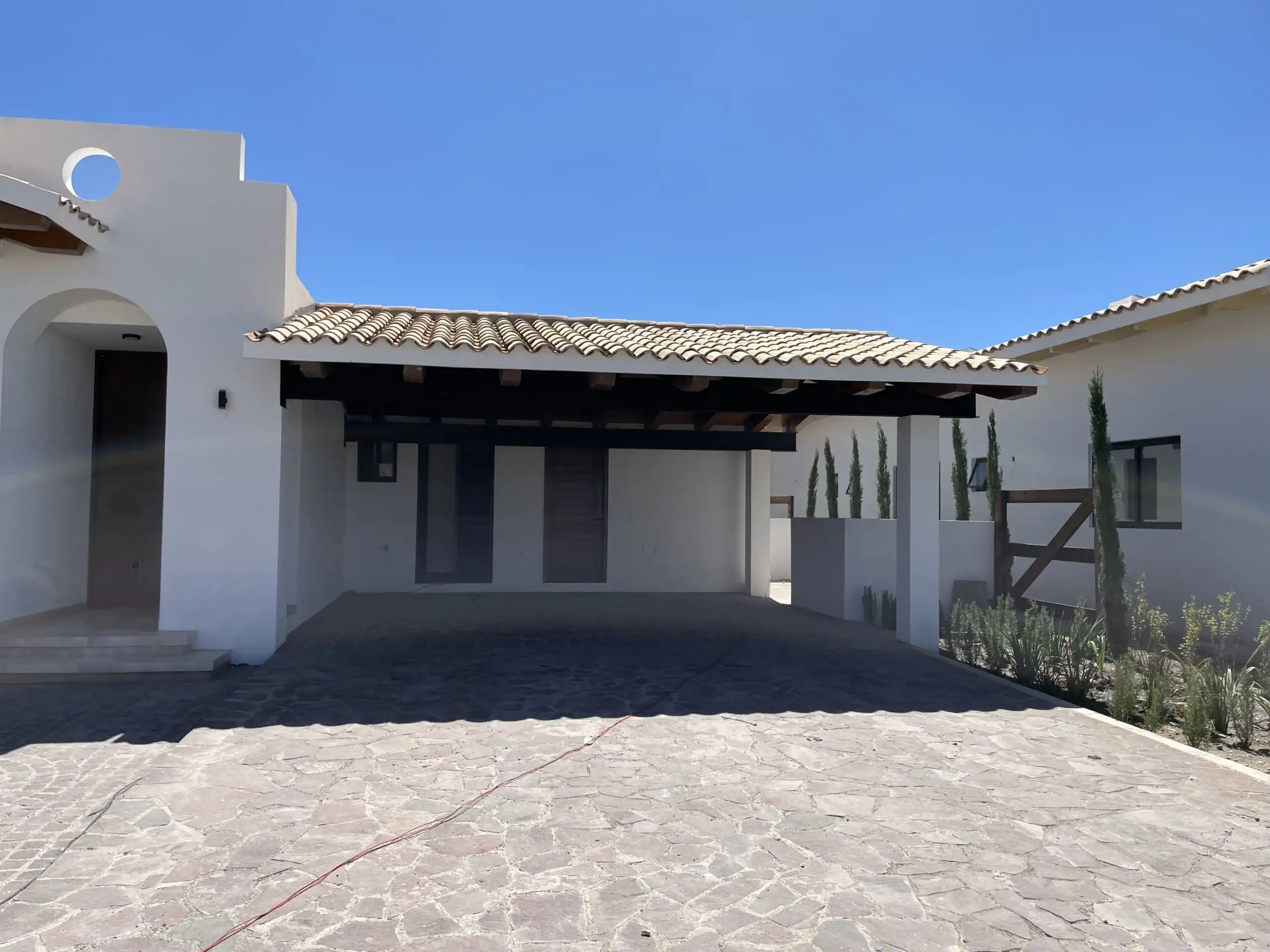 Beautiful white estate with a tiled roof and spacious driveway.