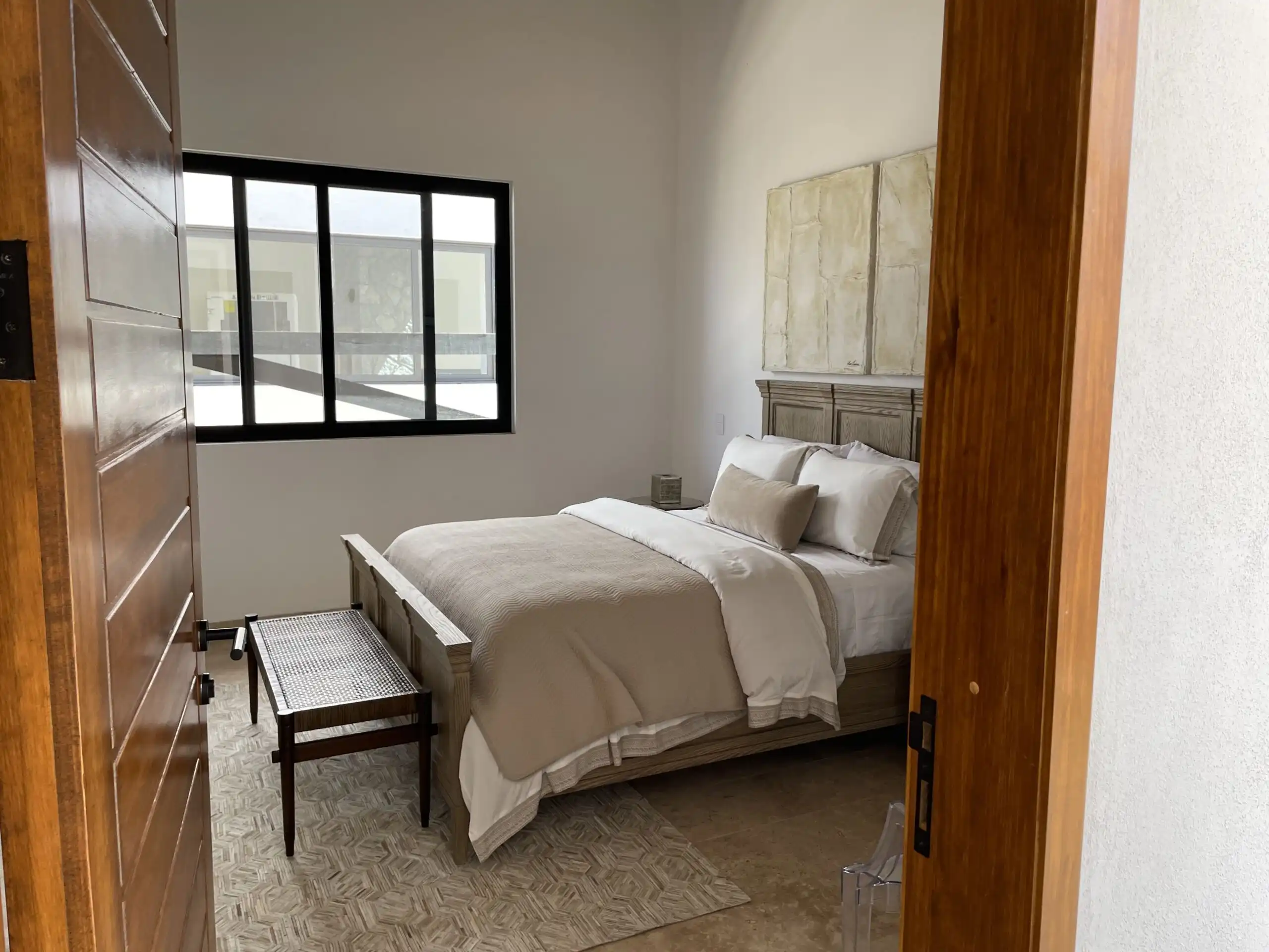 Luxury bedroom with natural light and elegant furnishings in Casa Renacer estate.