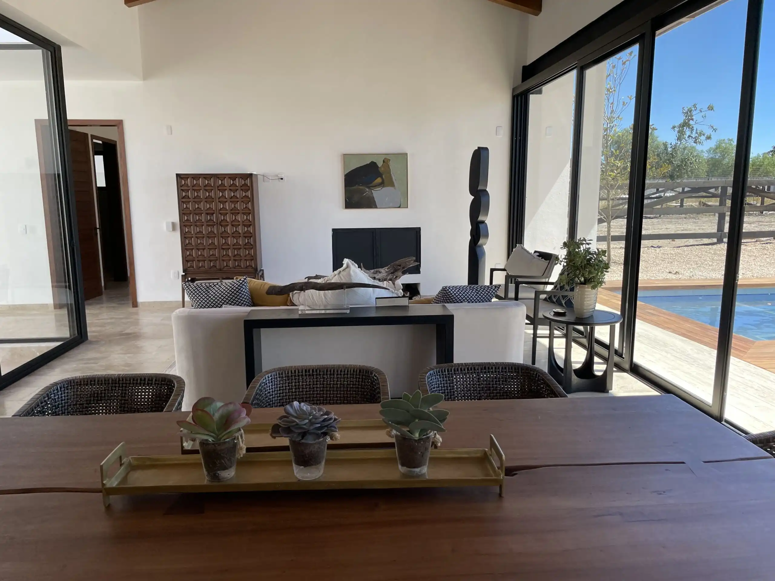 Spacious living area in Casa Renacer, featuring large glass doors opening to outdoor scenery.