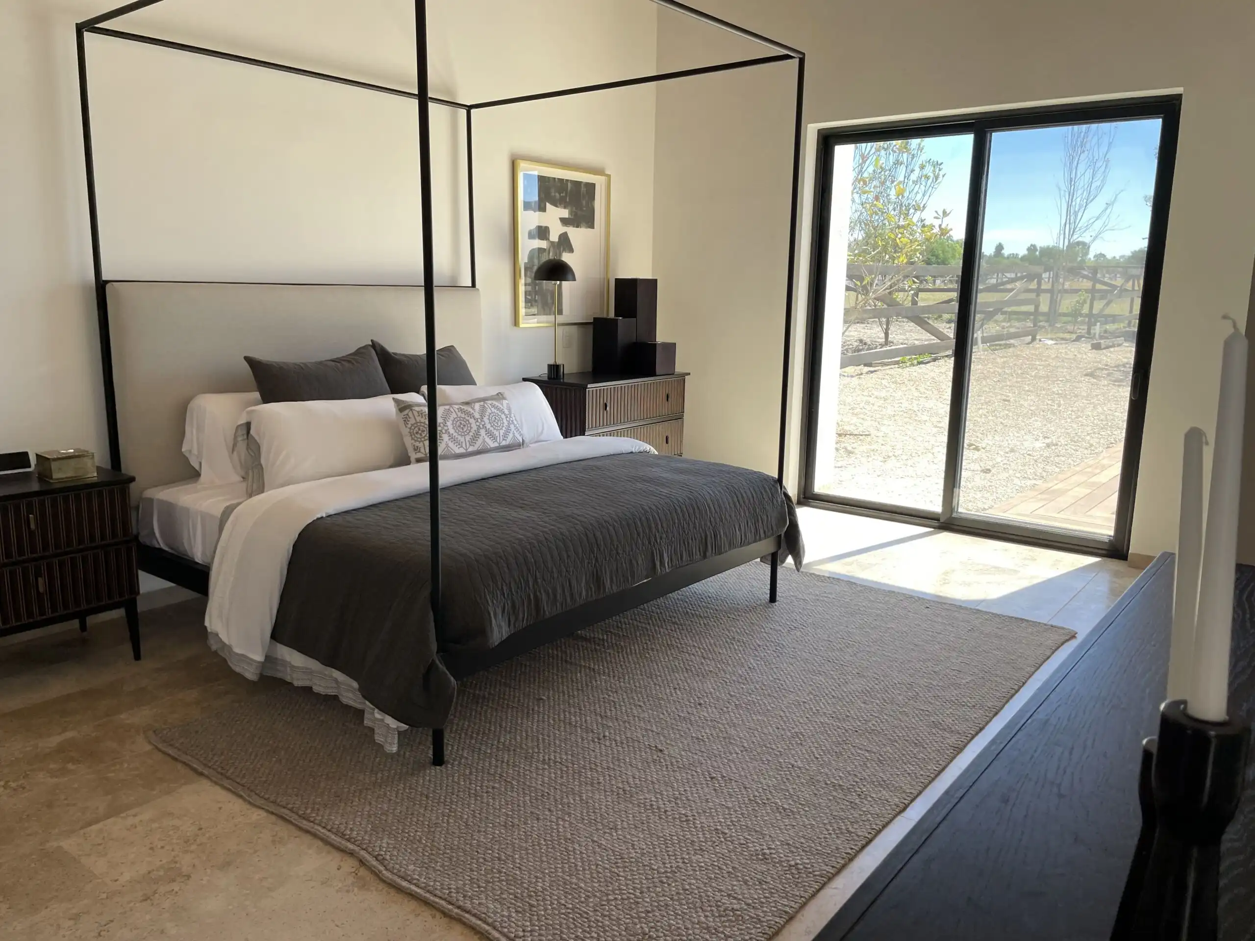 Elegant bedroom with modern decor and large window views.