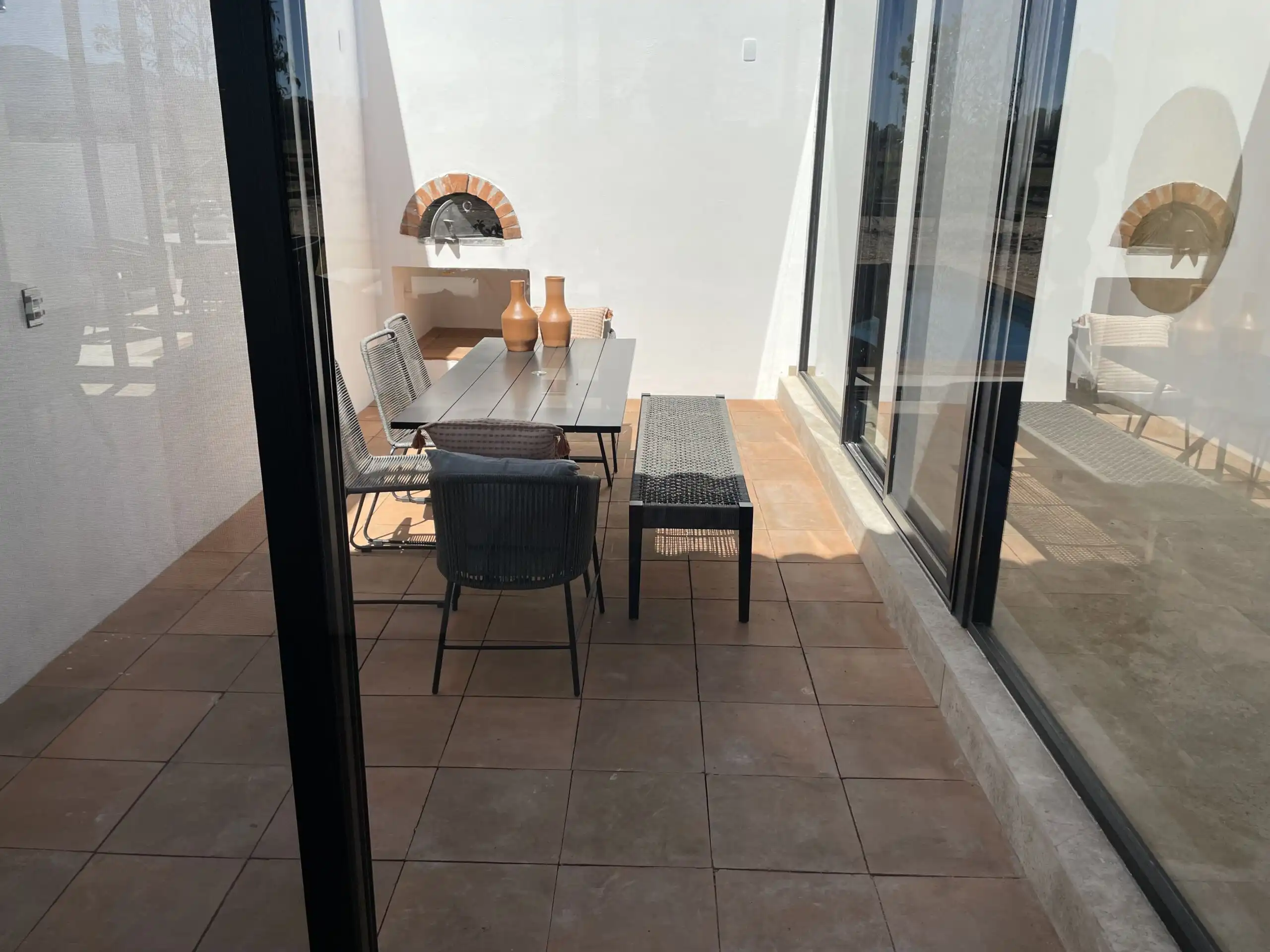Aluminum and glass enclosed patio with outdoor dining area.