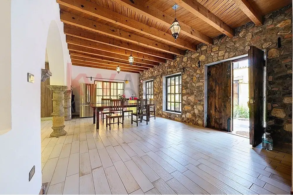 Style 4-Bedroom Home Interior Style living room with wooden ceiling, stone walls, and large windows in San Miguel de Allende.