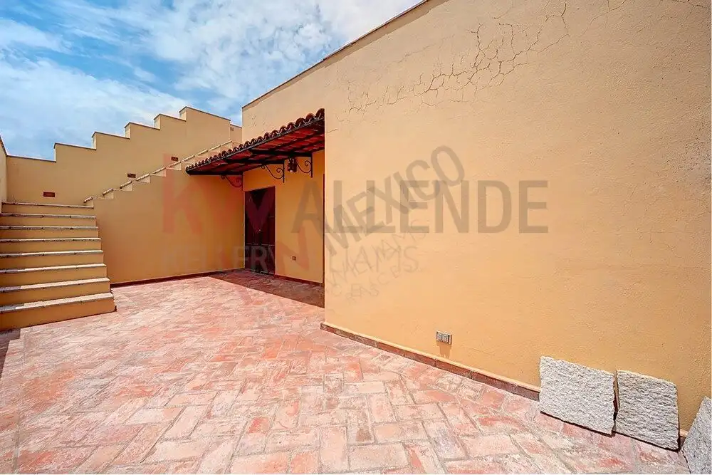 Style Home Exterior Bright exterior view of a colonial-style home with terracotta flooring and stucco walls in San Migue.