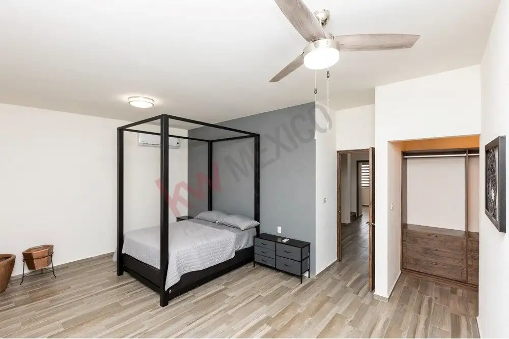 Elegant bedroom featuring a black four-poster bed and contemporary furnishings.