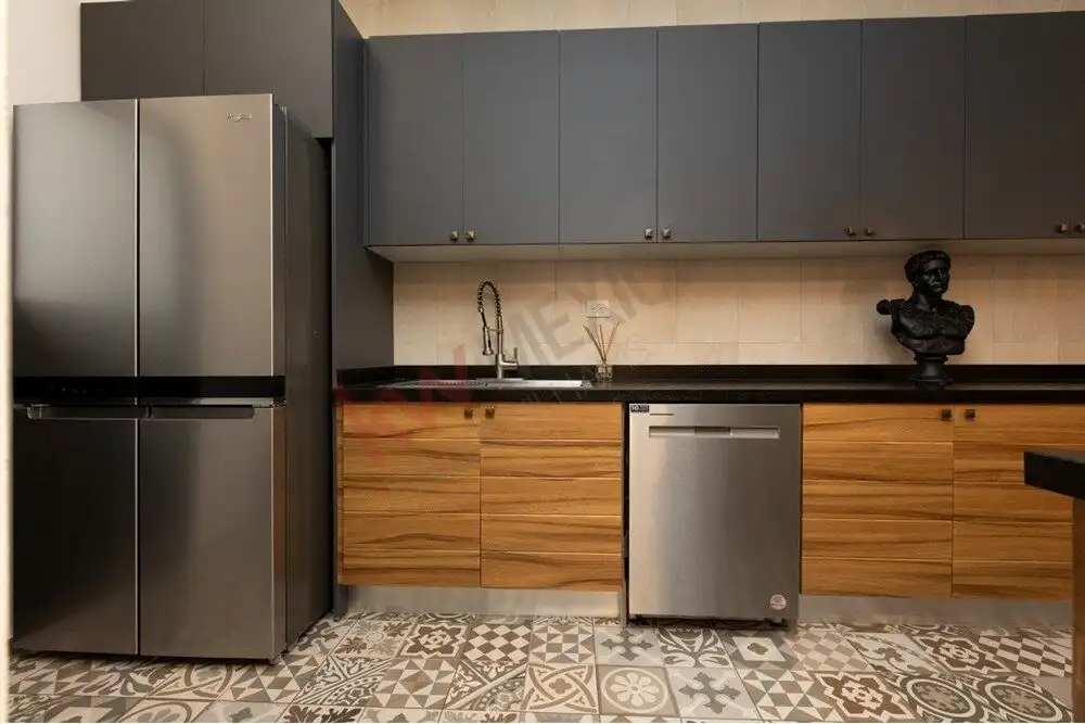 Contemporary kitchen featuring stylish cabinets, a refrigerator, and a dishwasher.