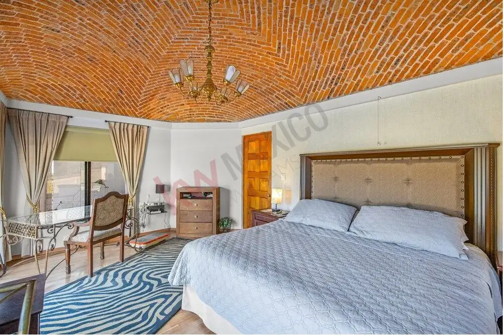 Elegant bedroom featuring a brick vaulted ceiling and classic furnishings in San Miguel de Allende.