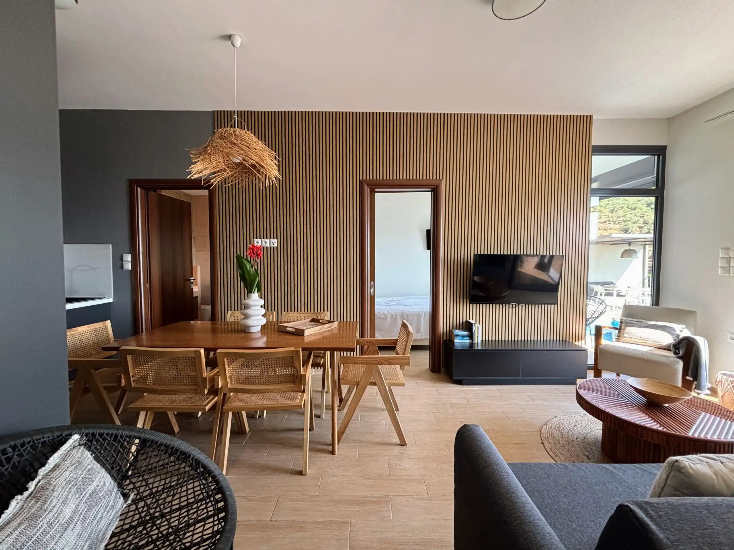 Modern villa living room with sea view, wooden accents, and stylish furniture in Skiathos, Greece.