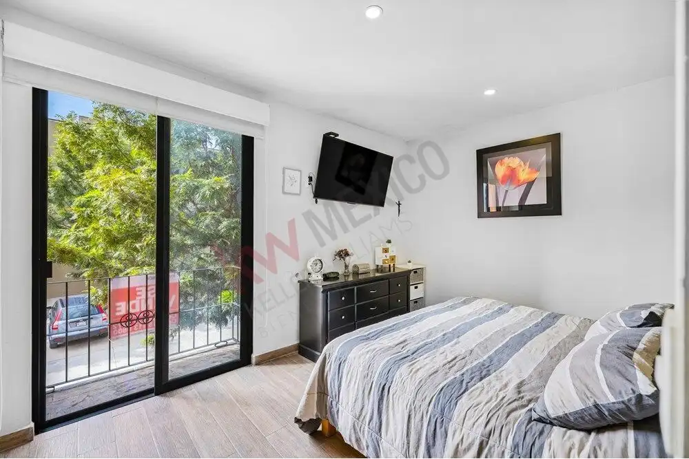 Bright bedroom with large sliding glass doors and balcony views.