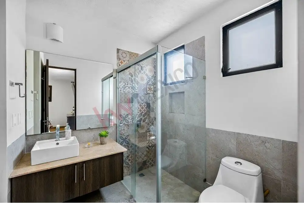 Bathroom with modern fixtures and tiled accents in a stylish San Miguel de Allende home.