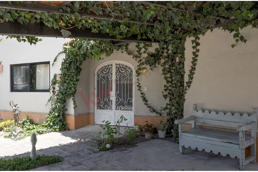 Charming Rancho Los Labradores Home Beautiful entrance with wrought iron gate and lush greenery in San Miguel de Allende.