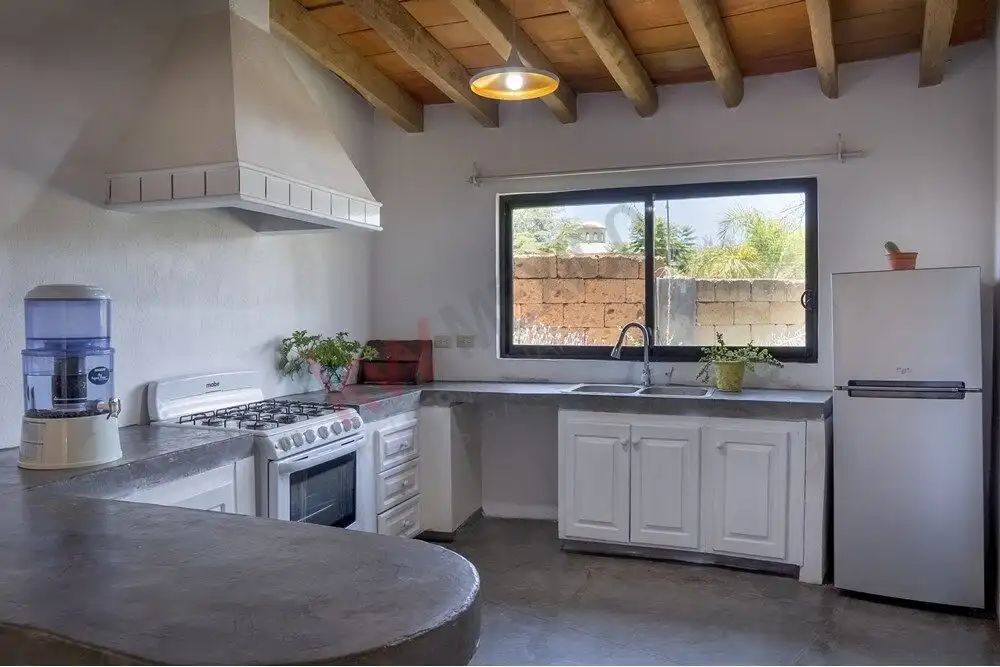 Modern kitchen in Rancho Los Labradores home Bright kitchen with white cabinets and large window in San Miguel de Allende.