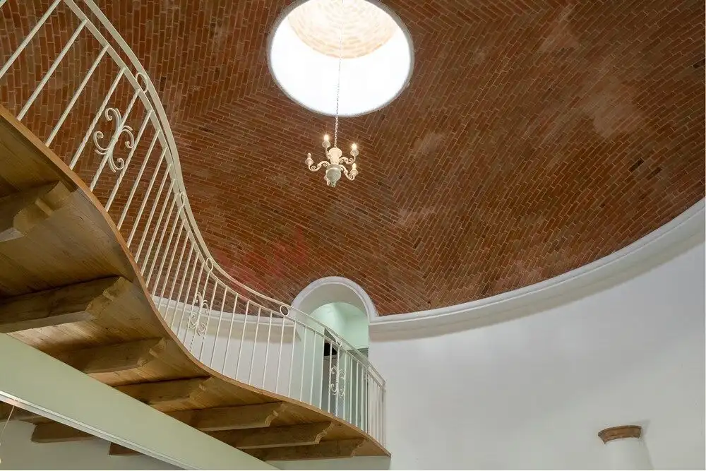 Charming Modern House in San Miguel de Allende Spacious interior with a stunning brick vaulted ceiling and elegant chandelier.