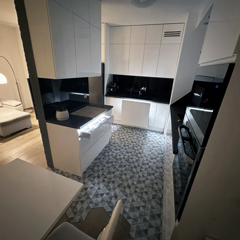 Interior view of a modern 2-bedroom apartment in Warsaw with sleek kitchen and contemporary furnishi.