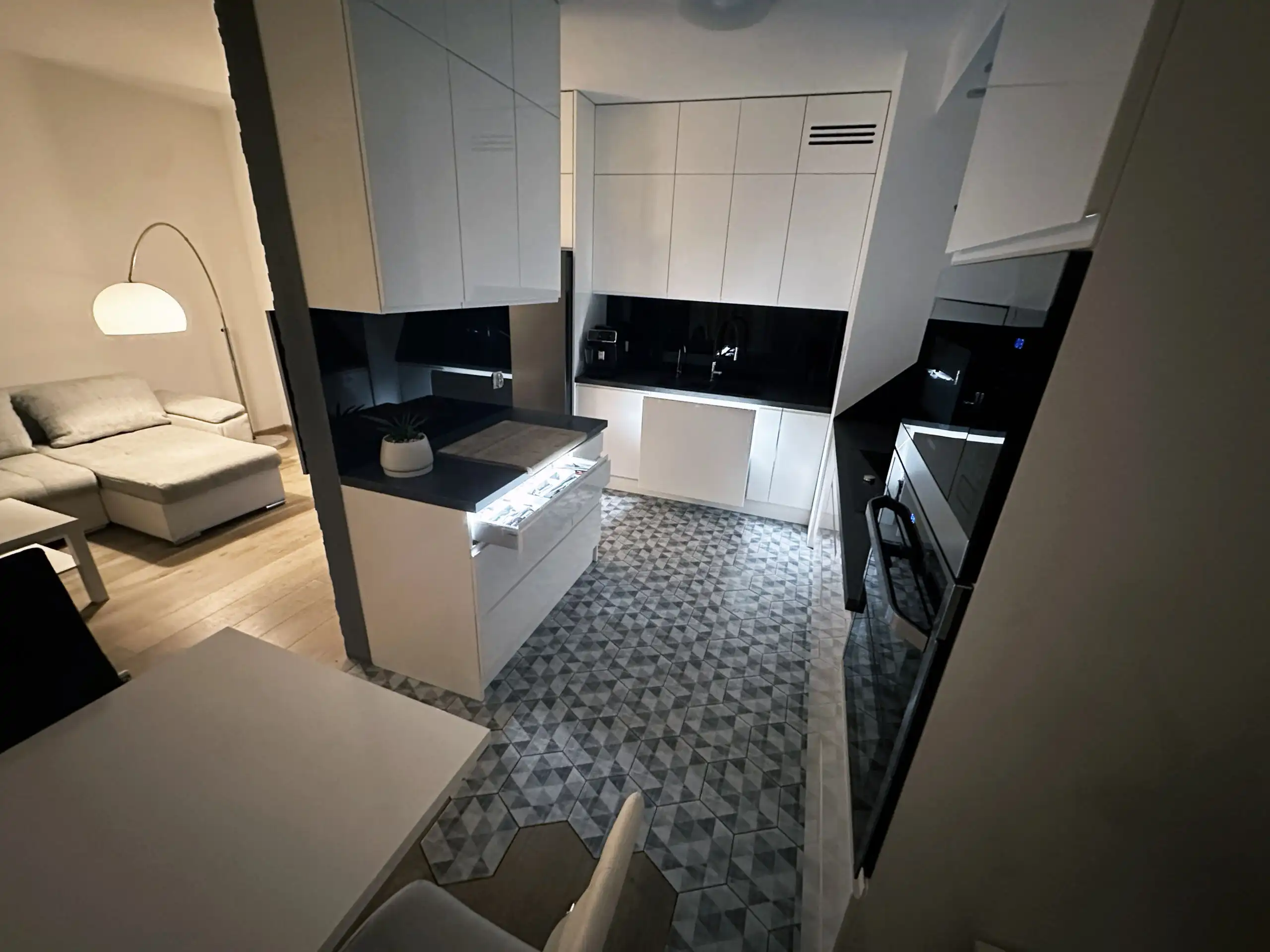 Interior view of a modern 2-bedroom apartment in Warsaw with sleek kitchen and contemporary furnishi.