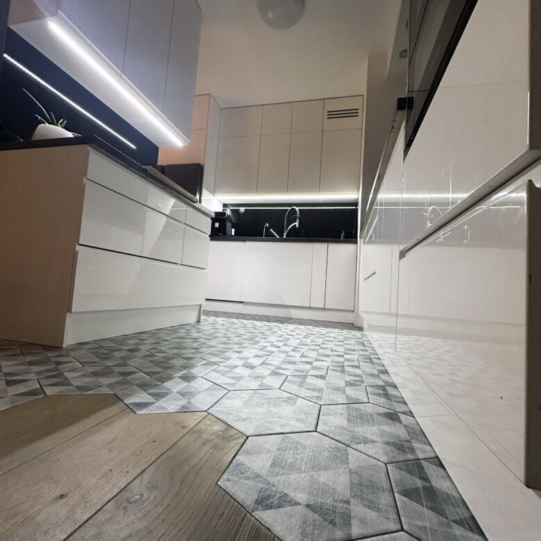 Bright and stylish kitchen in a Warsaw apartment with sleek white cabinetry and contemporary design.