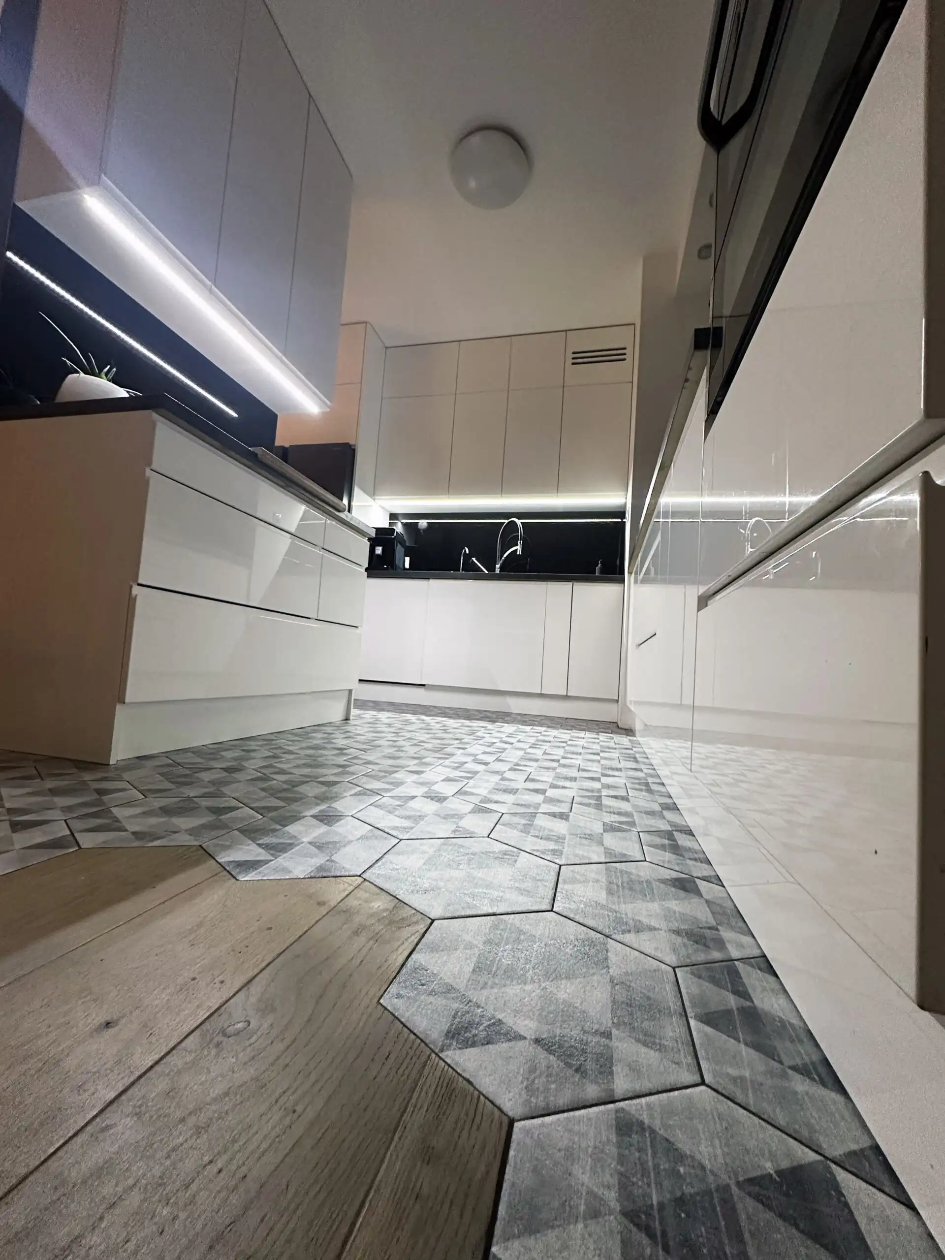 Bright and stylish kitchen in a Warsaw apartment with sleek white cabinetry and contemporary design.