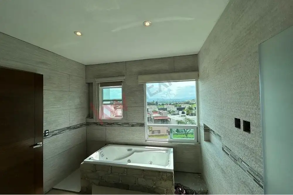 Bright bathroom featuring a Jacuzzi tub and large windows with city views in San Miguel de Allende.