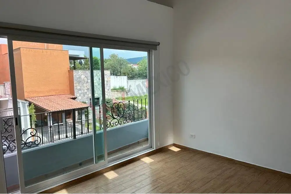 Bright interior room with large sliding glass door leading to balcony in San Miguel de Allende.