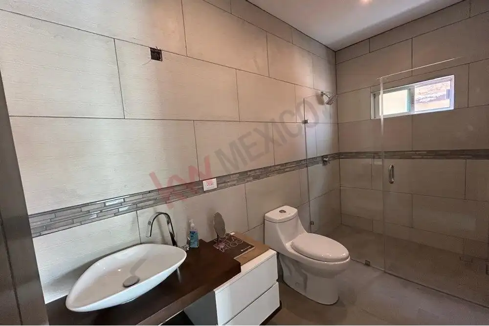 Bright bathroom with contemporary fixtures and neutral tile design in El Capricho, San Miguel de All.