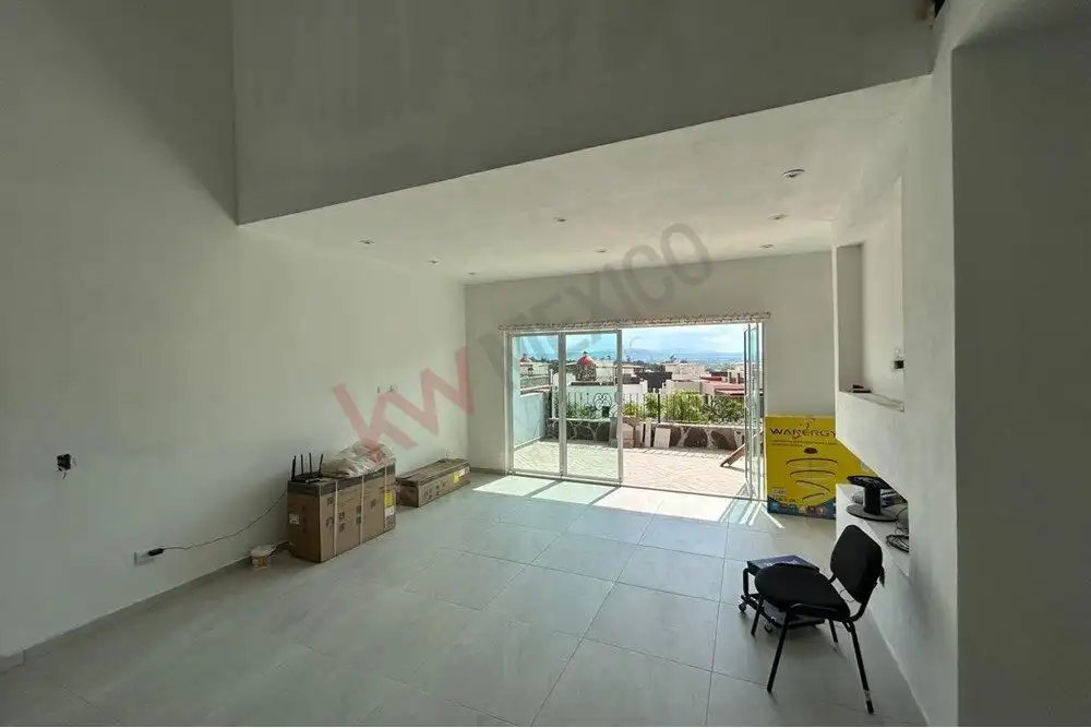 Spacious interior with large glass doors opening to a scenic outdoor terrace.