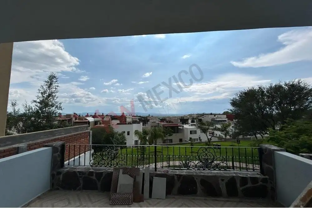 View from balcony of San Miguel de Allende with cityscape and sky.