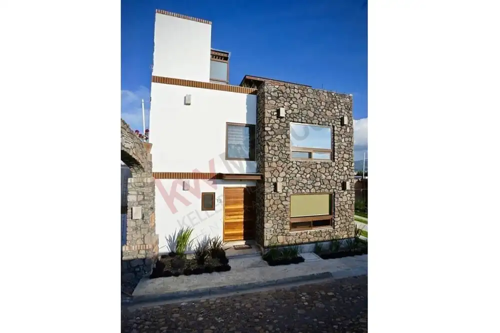 Contemporary 2-bedroom house with stone accents, wooden door, and rooftop terrace in San Miguel de A.