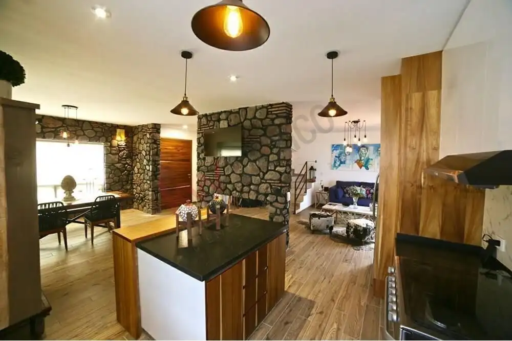 Interior view of a 2-bedroom house with stone accents, modern kitchen, and living area in San Miguel.